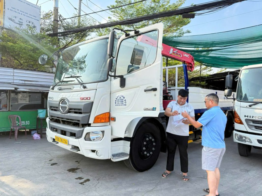 Hình ảnh hai vị khách hàng đang kiểm tra và nhận bàn giao chiếc xe tải cẩu “hàng tuyển siêu lướt” tại bãi xe Công ty Trường Phát.